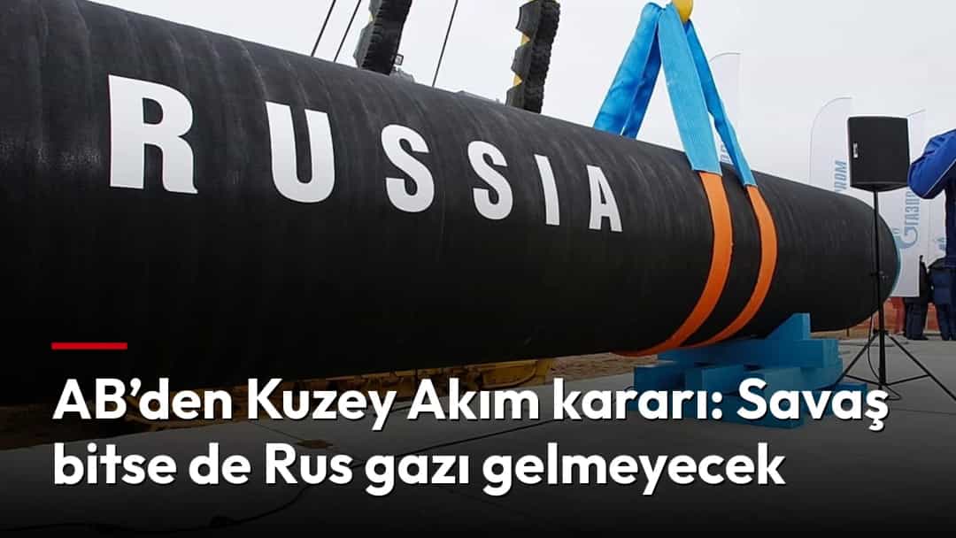 Vinçle kaldırılan ve üzerinde “RUSSIA” yazan büyük bir borunun yanında bir işçi duruyor.