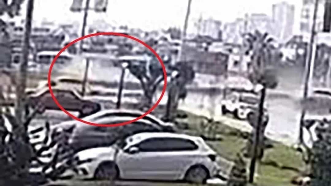 Güvenlik kamerası görüntüsünde, kırmızı daireyle işaretlenmiş bir aracın bulunduğu yol ve çevresi.