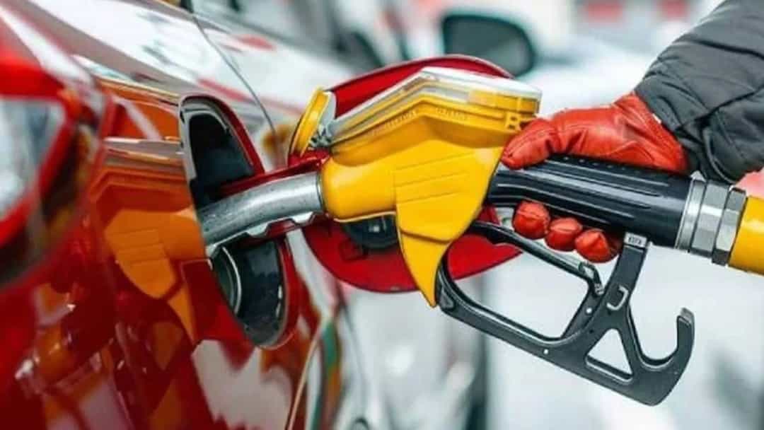 Akaryakıt pompasının tabancası kırmızı bir otomobilin deposuna yakıt dolduruyor.