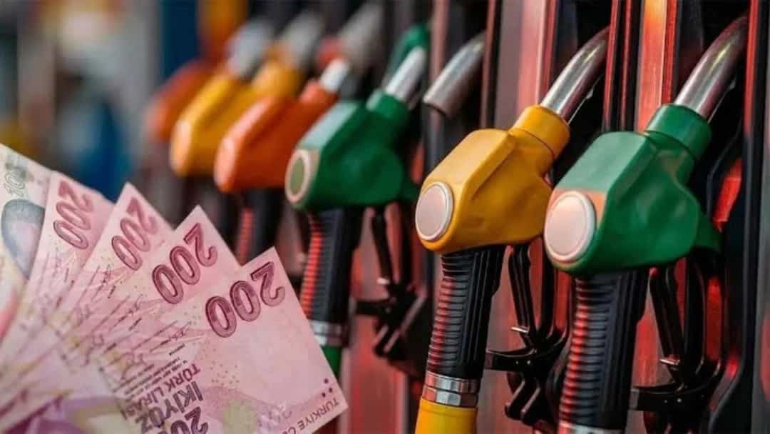 Akaryakıt tabancalarının önünde Türk lirası banknotları.