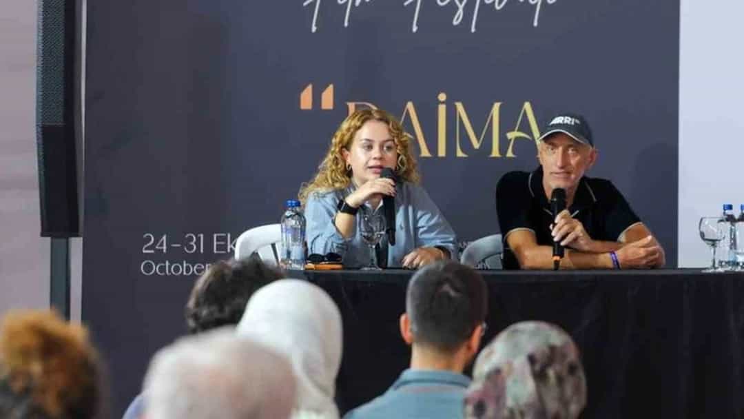 Antalya Altın Portakal Film Festivali’nde iki konuşmacı, izleyicilerin önünde bir panelde konuşuyor.