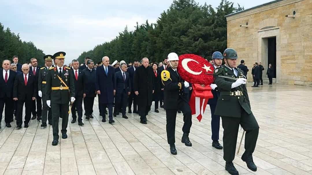 Anıtkabir’de Cumhuriyet Bayramı töreni için Türk bayrağı ve çelenk taşıyan görevlilerin önünde yürüyen yurttaşlar ve resmi heyet.