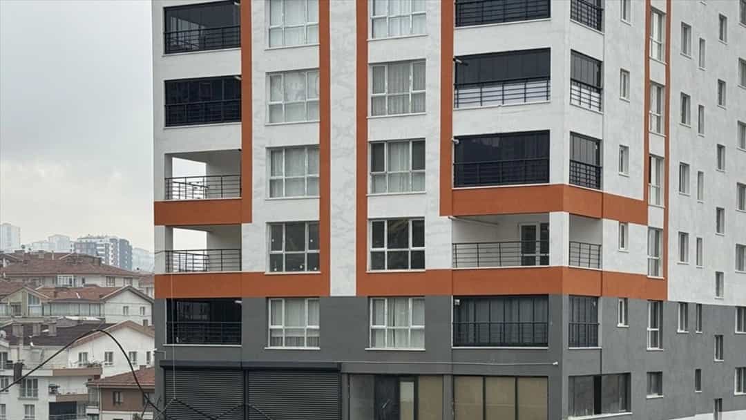 Toprak yığını ve istinat duvarı çevresinde görülen çok katlı apartman.