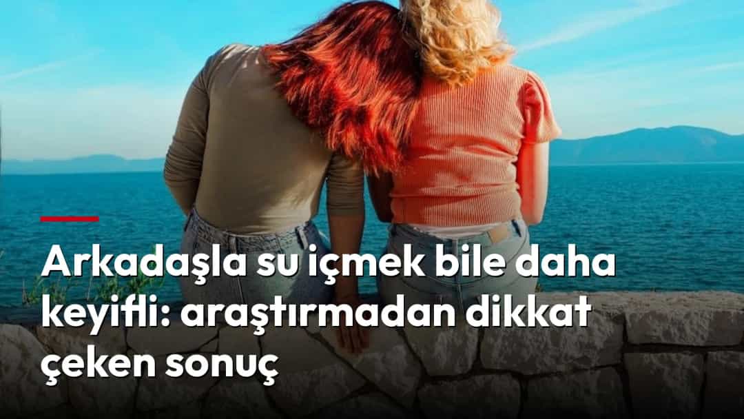 Deniz kıyısındaki taş duvarda yan yana oturan iki arkadaş