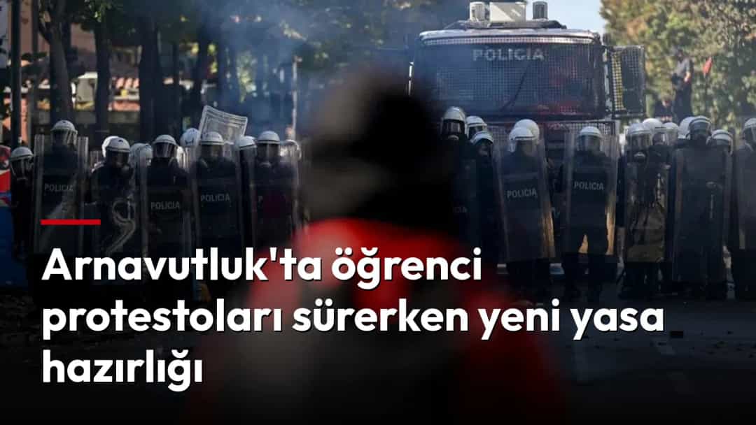 Gösteri sırasında kalkanlarıyla barikat kuran polislerin önünde bulanık bir kişi görülüyor.