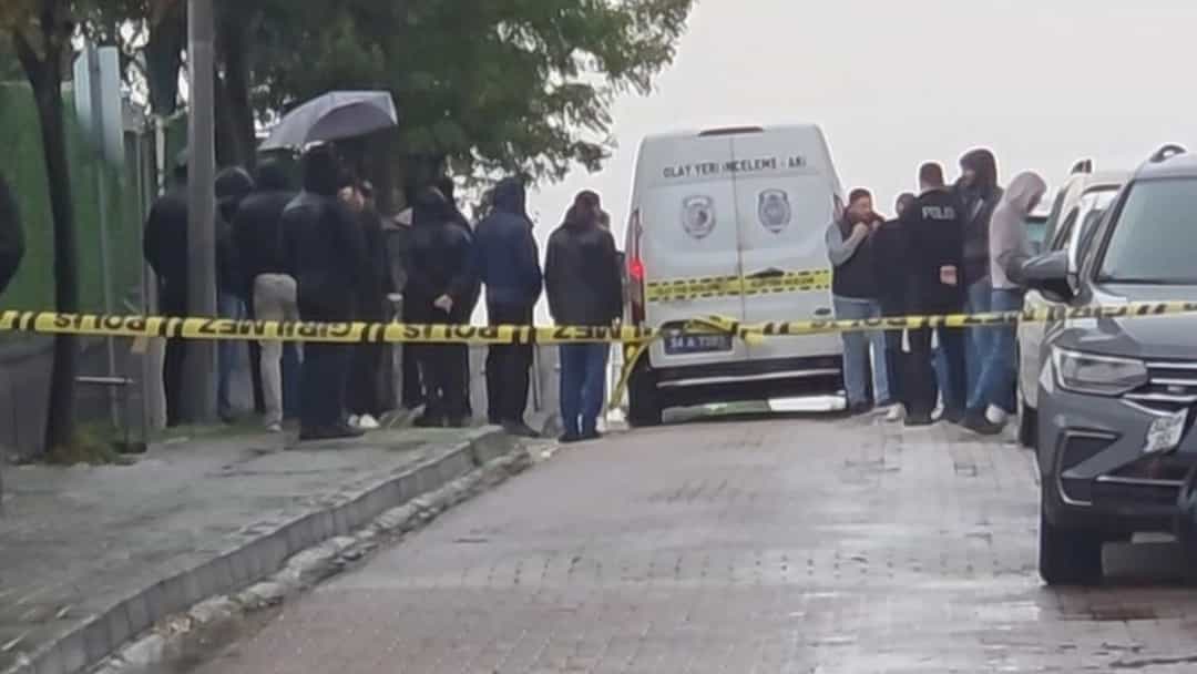 Avcılar'da bir sokakta, güvenlik şeridinin arkasında toplanan kişiler ve olay yerine gelen araçlar