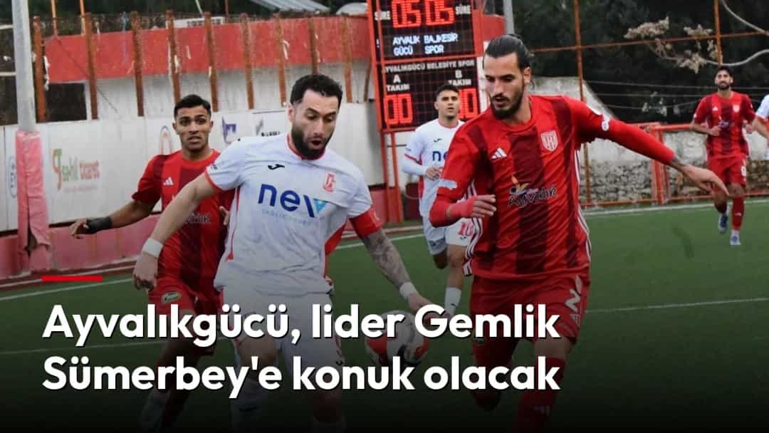 Kırmızı ve beyaz formalı futbolcular, maç sırasında top için mücadele ediyor.