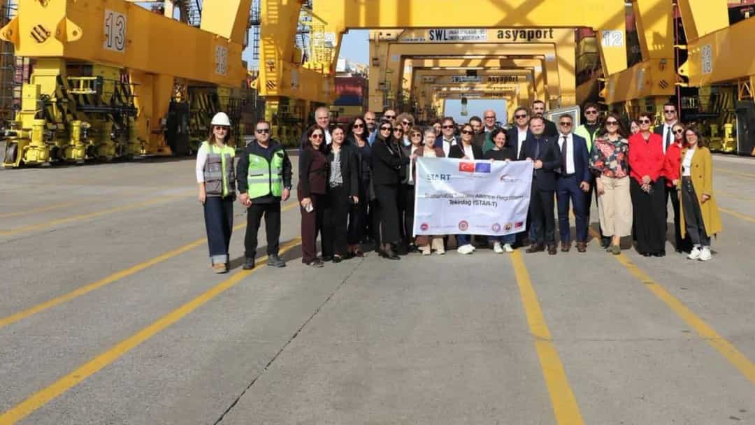 Bir grup ziyaretçi Tekirdağ’daki limanda, sarı yük vinçlerinin önünde toplu fotoğraf çektiriyor.