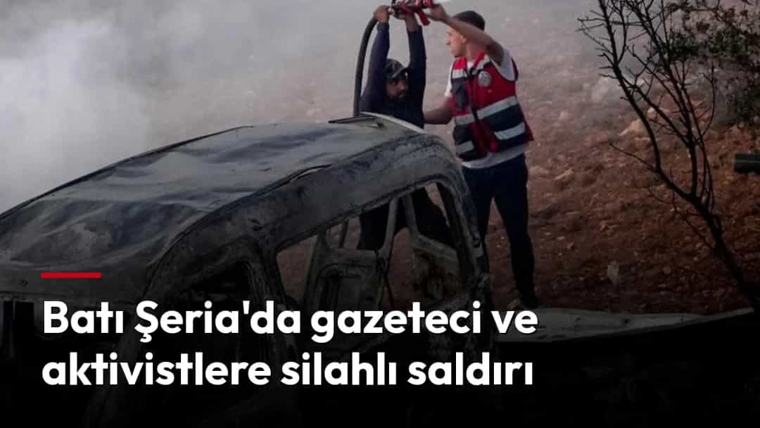 Yanmış bir aracın yanında duran iki kişi, dumanlar arasında aracı inceliyor.