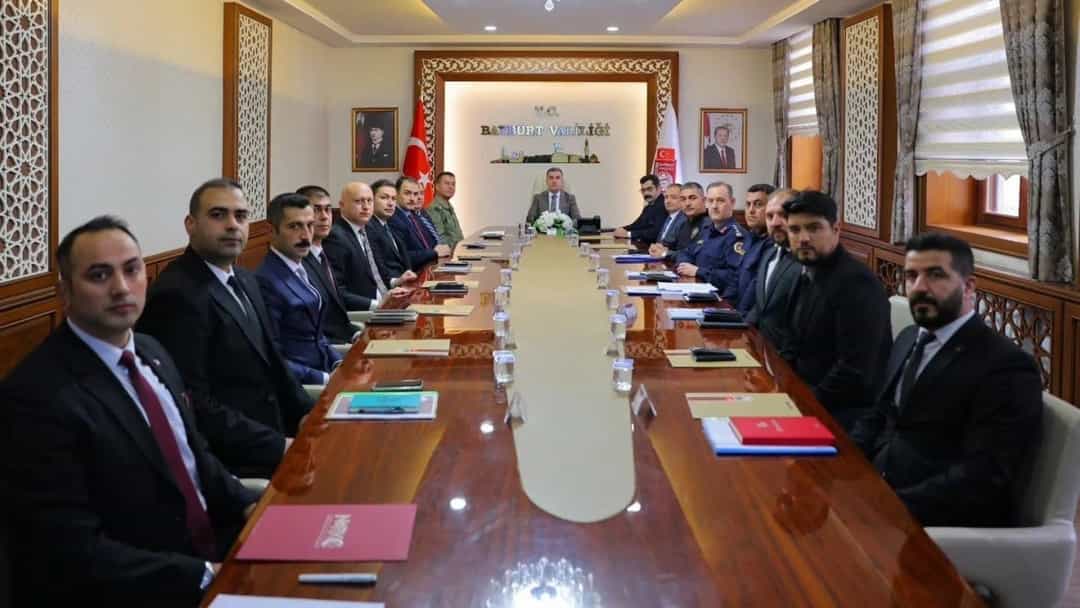 Bayburt'ta güvenlik ve asayiş konularının görüşüldüğü toplantıda katılımcılar uzun bir masa çevresinde bir araya geldi.