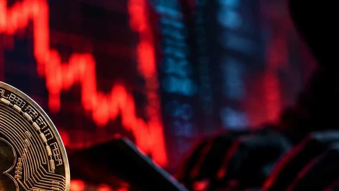 Bitcoin ve Ethereum temalı kripto para madeni paraları, arka planda kırmızı piyasa grafikleriyle birlikte görülüyor.