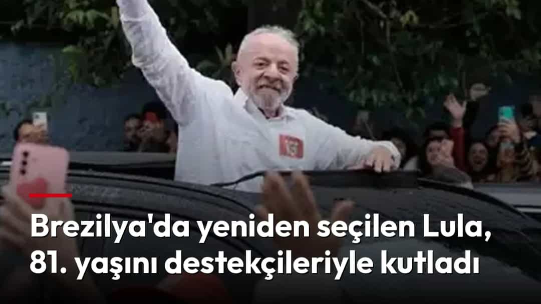 Luiz Inácio Lula da Silva, aracın üzerinden kalabalığı selamlarken yumruğunu havaya kaldırıyor.