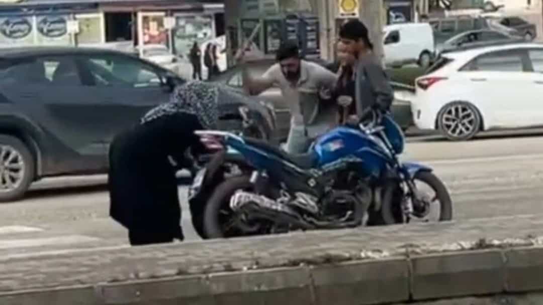 Yol kenarında bir motosikletin çevresinde toplanan kişiler