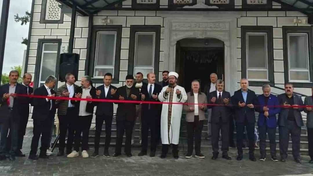 Sait Ağa Camisi önünde düzenlenen açılış töreninde katılımcılar kurdele kesiyor.