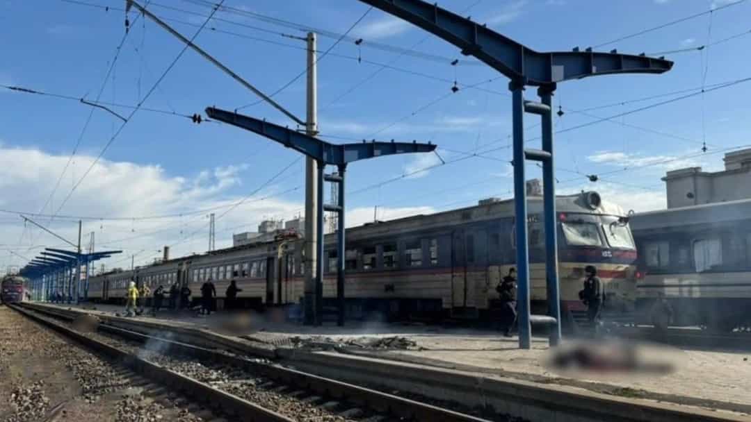 Dnipro’daki tren istasyonunda peronda duran yolcu treni ve demiryolu hatları.