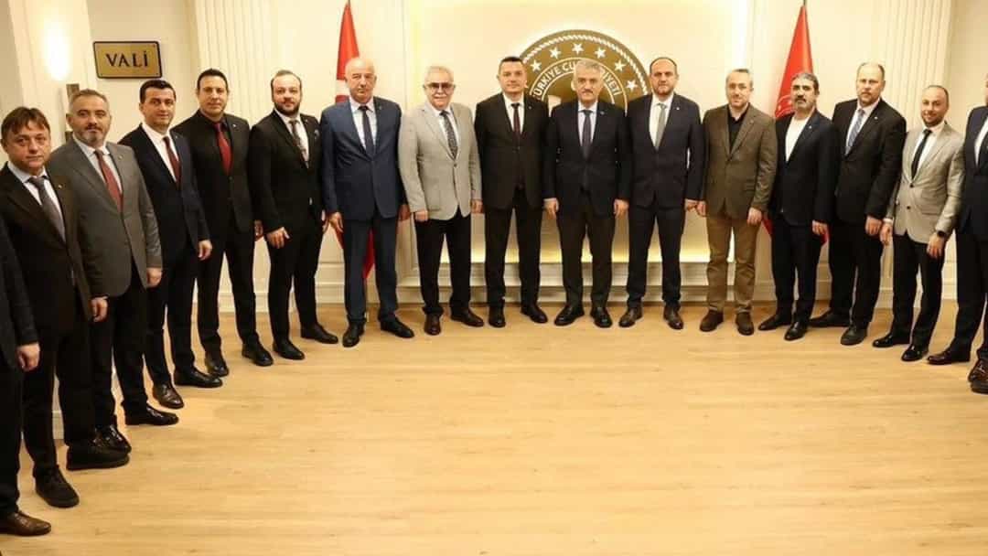 DTSO yönetimi, resmi bir salonda Vali Mehmet Makas ile birlikte toplu fotoğraf çektiriyor.