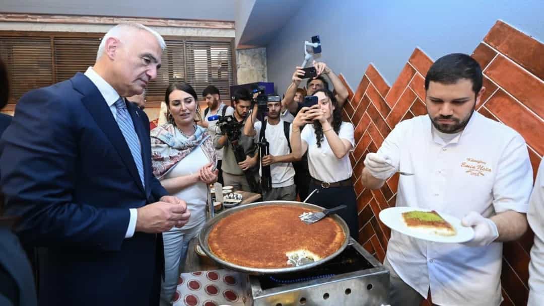 Mehmet Nuri Ersoy, geleneksel bir tatlıyı hazırlayan aşçıyı izliyor.