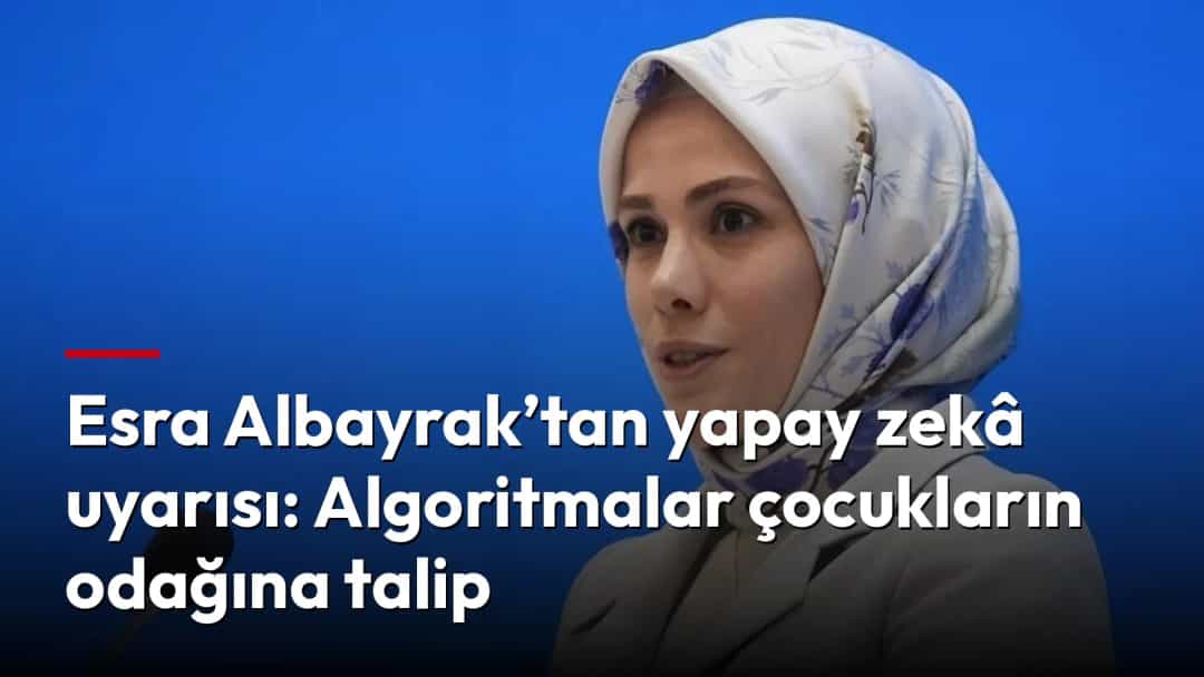 Esra Albayrak, mavi fon önünde mikrofonla konuşuyor.