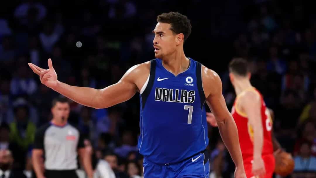 Dallas Mavericks forması giyen Dwight Powell, maç sırasında takım arkadaşına doğru işaret ediyor.