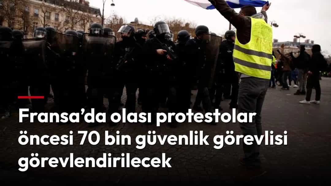Fransa’da bir protesto sırasında sarı yelekli bir gösterici, kalkanlı polislerin önünde kırmızı bir kumaş sallıyor.
