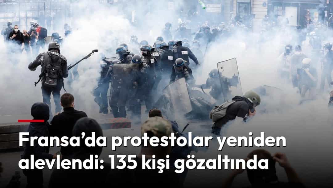 Fransa’da bir protesto sırasında yoğun dumanın içinde ilerleyen çevik kuvvet polisleri ve kalabalık.