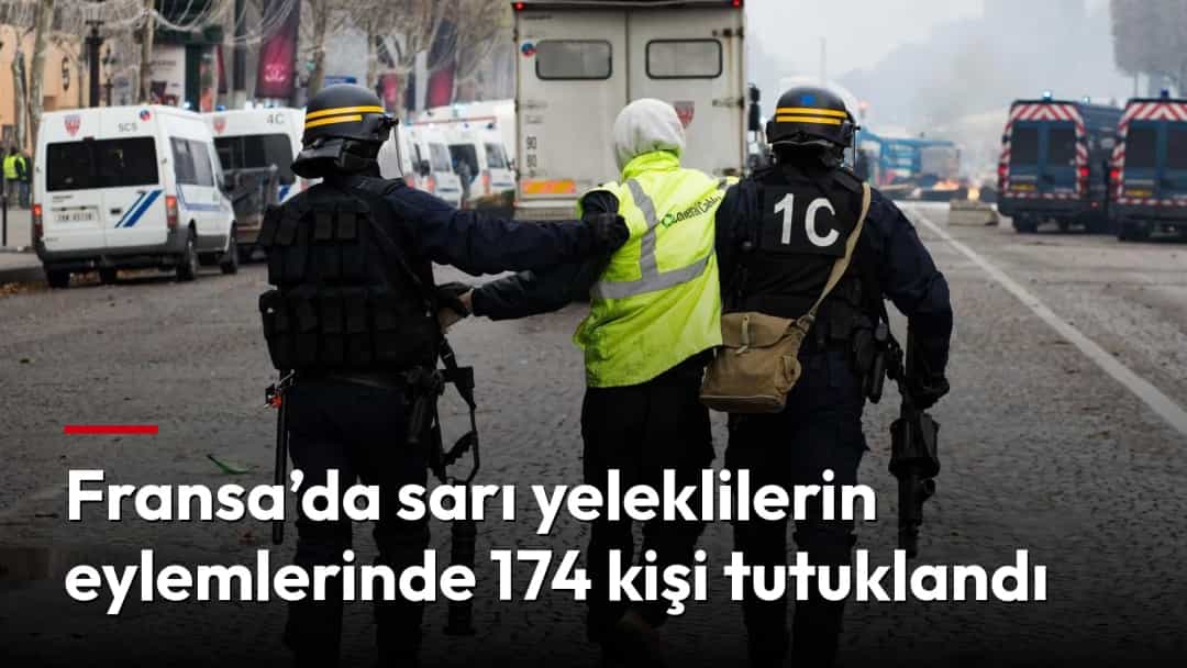 Polisler, sarı yelekli bir eylemciyi sisli bir Paris caddesinde götürüyor.
