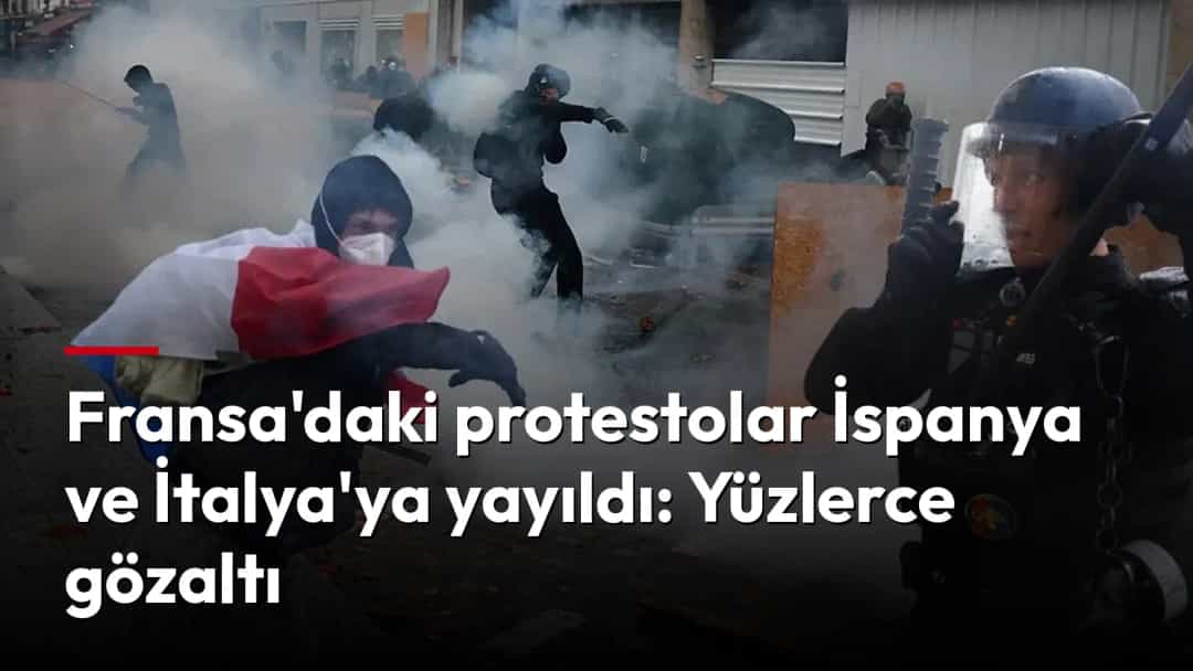 Fransa bayrağına sarınmış bir protestocu ile çevik kuvvet polisi, yoğun dumanın ortasında karşı karşıya.