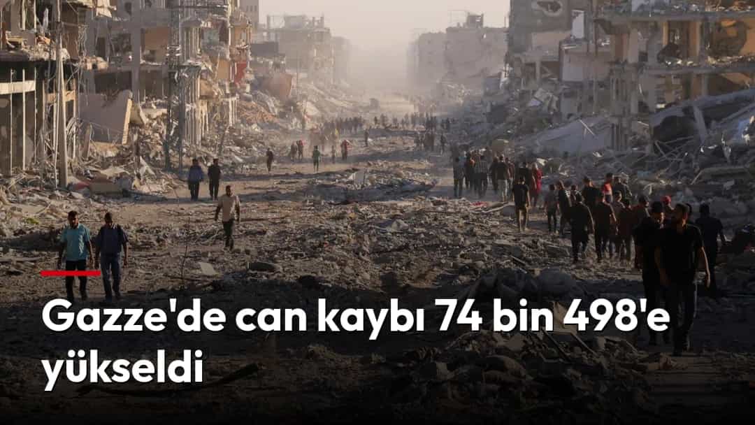 Gazze'de ağır hasar gören bir cadde enkazla kaplanırken insanlar yıkıntılar arasında ilerliyor.