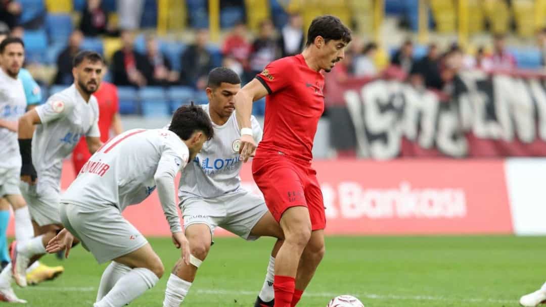 Gençlerbirliği’nin kırmızı formalı futbolcusu, Karaköprü Belediyesporlu oyuncuların arasında topla ilerliyor.
