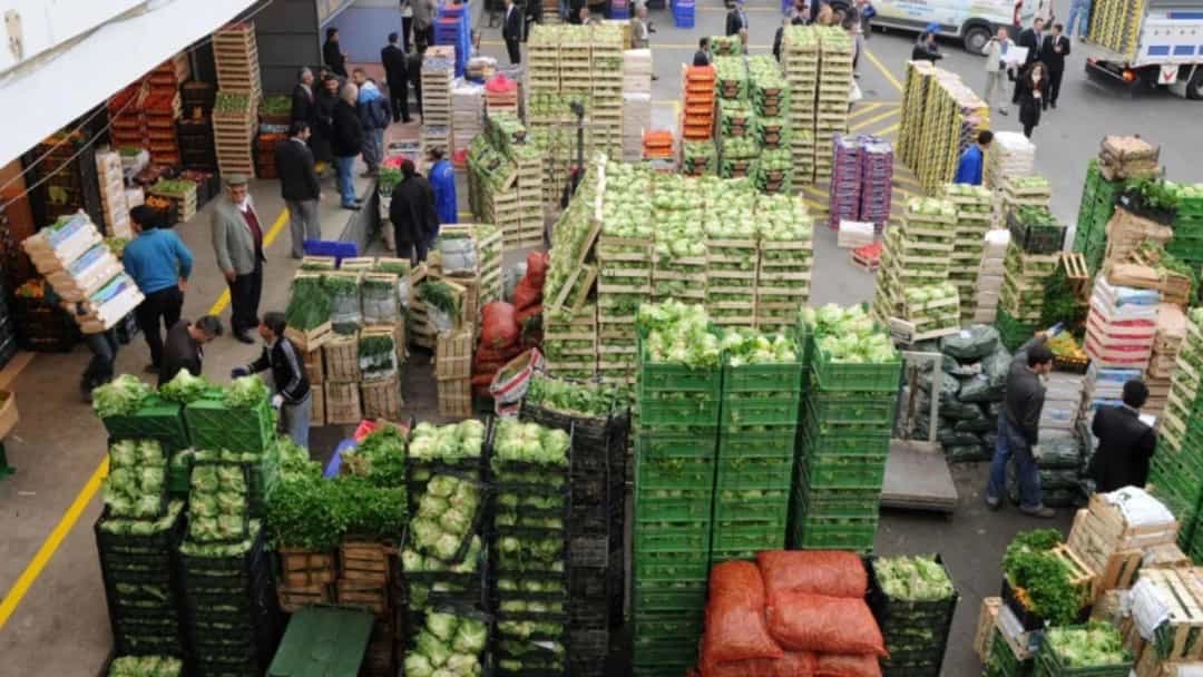 Sebze ve meyve kasalarının sıralandığı toptancı halinde esnaf ve çalışanlar.
