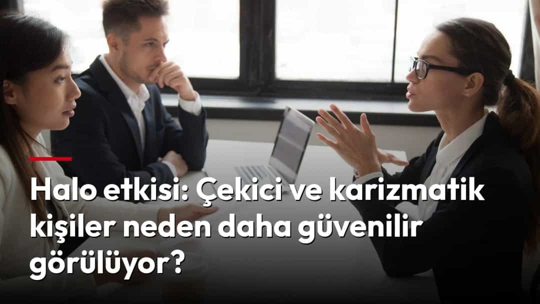 Gözlüklü bir kadın, toplantı masasında iki iş arkadaşına konuşurken el hareketleriyle düşüncelerini anlatıyor.