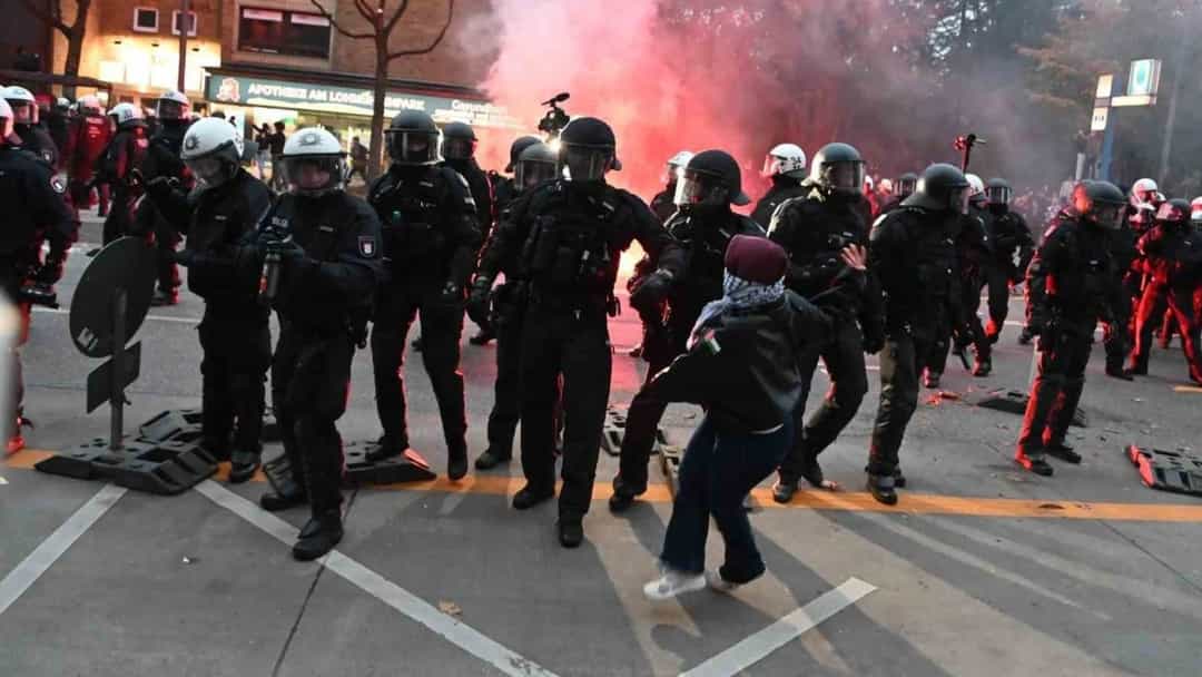 Hamburg'daki protestoda polisler, pembe duman yükselirken göstericilerle karşı karşıya.
