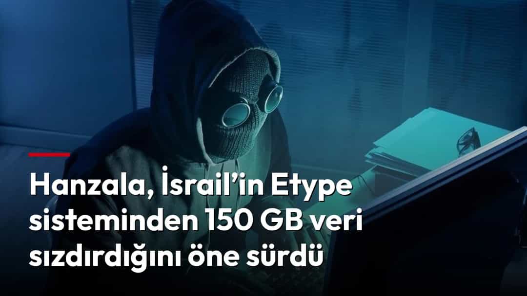 Kapüşonlu ve yüzü maskeli bir kişi bilgisayar başında çalışıyor.