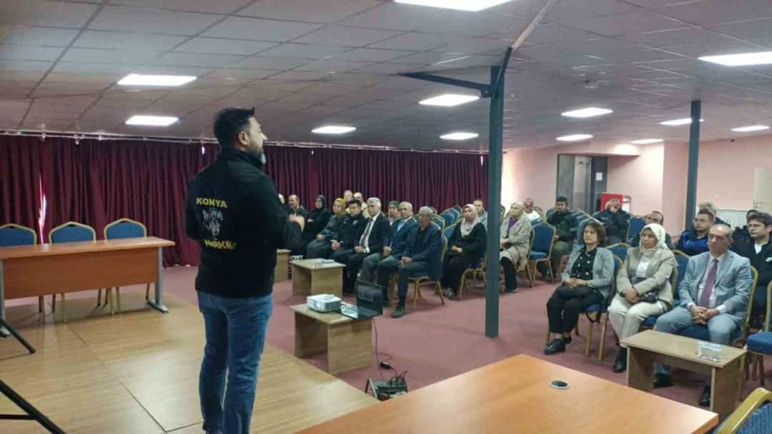 Bir görevli, salonda oturan katılımcılara narkotik konusunda eğitim veriyor.