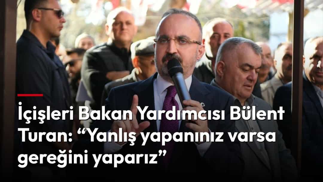 Bülent Turan, kalabalık önünde mikrofonla konuşurken.
