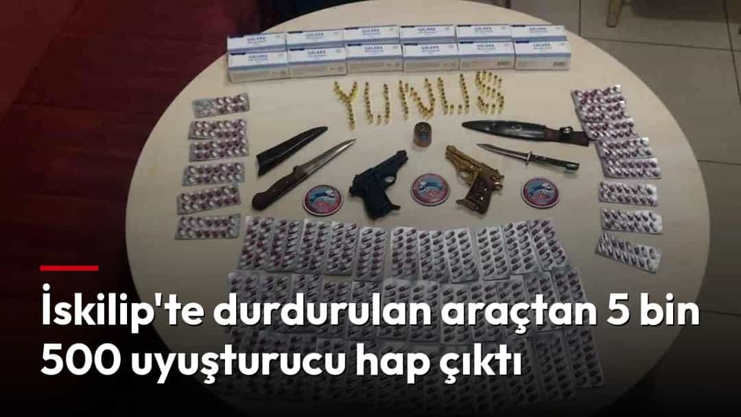 Durdurulan araçta ele geçirilen uyuşturucu haplar ve diğer materyaller masa üzerinde sergileniyor.