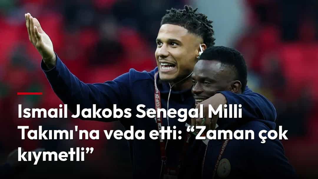 Ismail Jakobs, Senegal millî takımının eşofmanıyla bir takım arkadaşına sarılırken el sallıyor.