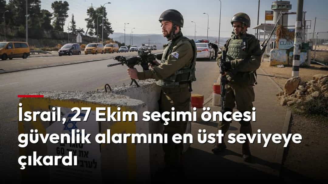 İsrail askerleri, yol kontrol noktasında silahlarıyla nöbet tutuyor.