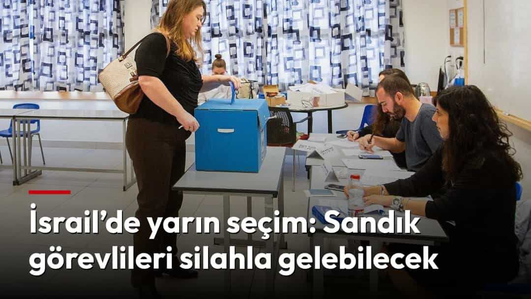 İsrail’de bir kadın, sandık görevlilerinin bulunduğu sınıfta oyunu sandığa atıyor.