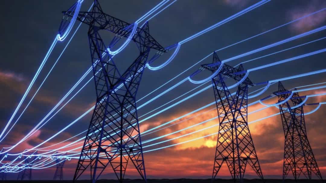 Gün batımında elektrik iletim hatları ve yüksek gerilim kuleleri
