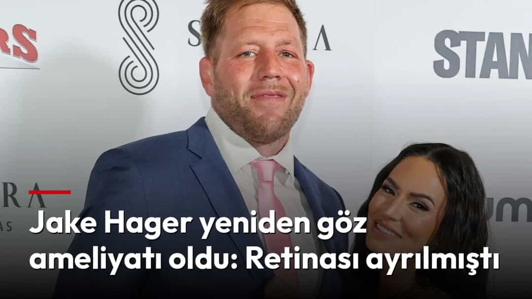 Jake Hager, pembe kravatlı mavi takım elbisesiyle bir etkinlikte poz veriyor.