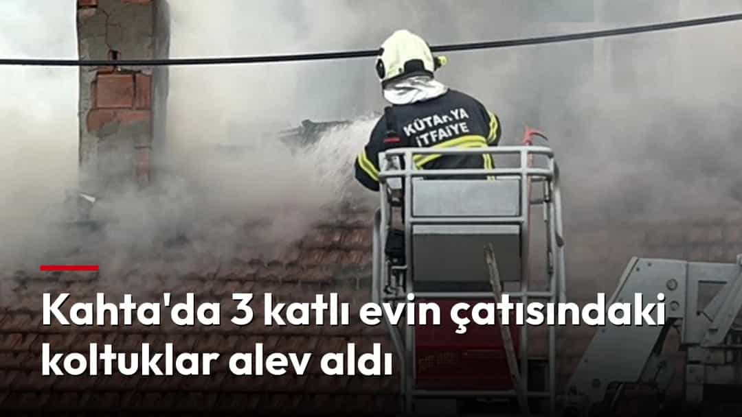 İtfaiye eri, dumanların yükseldiği kiremit çatıda yangına müdahale ediyor.