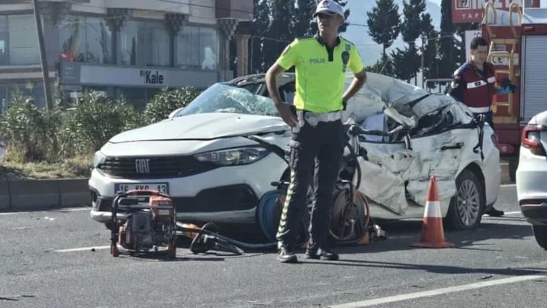 Adıyaman Kahta'da kaza sonrası ağır hasar gören otomobilin yanında güvenlik görevlileri ve olay yeri ekipmanı görülüyor.