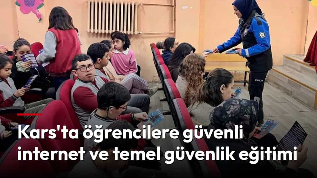 Polis memuru, sınıftaki öğrencilere güvenli internet ve temel güvenlik eğitimi sırasında broşür dağıtıyor.