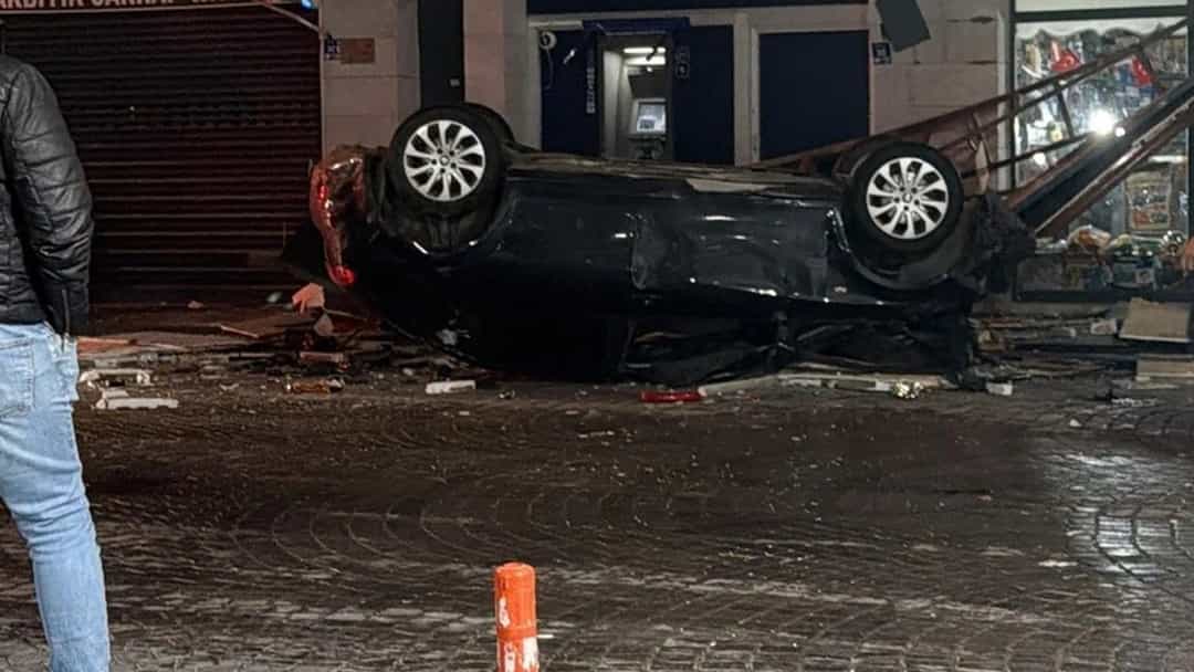 İş yerlerinin önünde ters dönmüş otomobil ve çevredeki hasar.