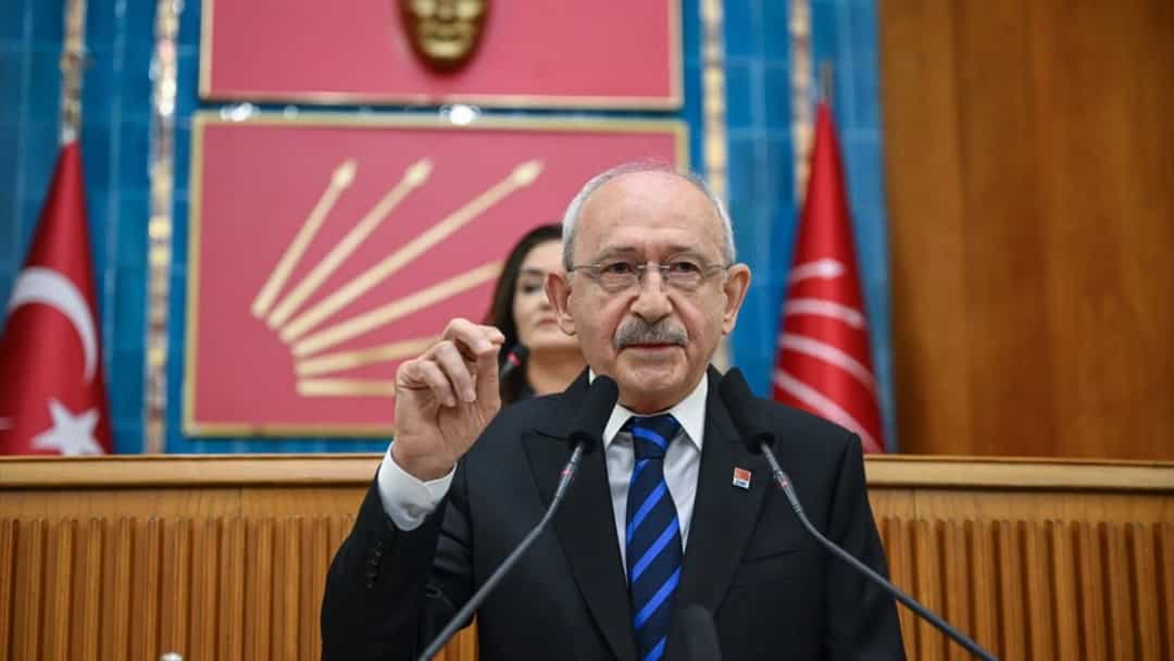 Kemal Kılıçdaroğlu kürsüde konuşurken elini kaldırıyor.