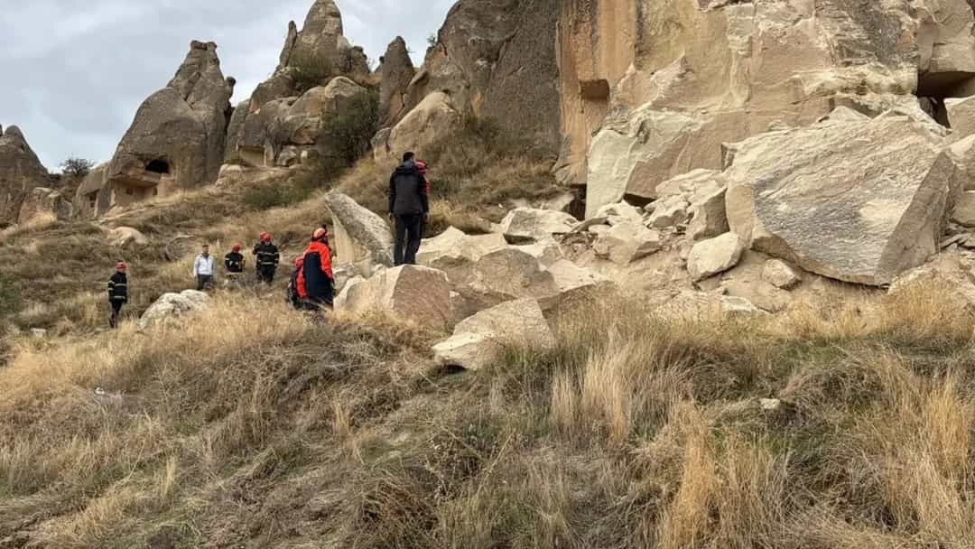Göreme’deki peribacaları ve kayalık arazide bulunan ziyaretçiler