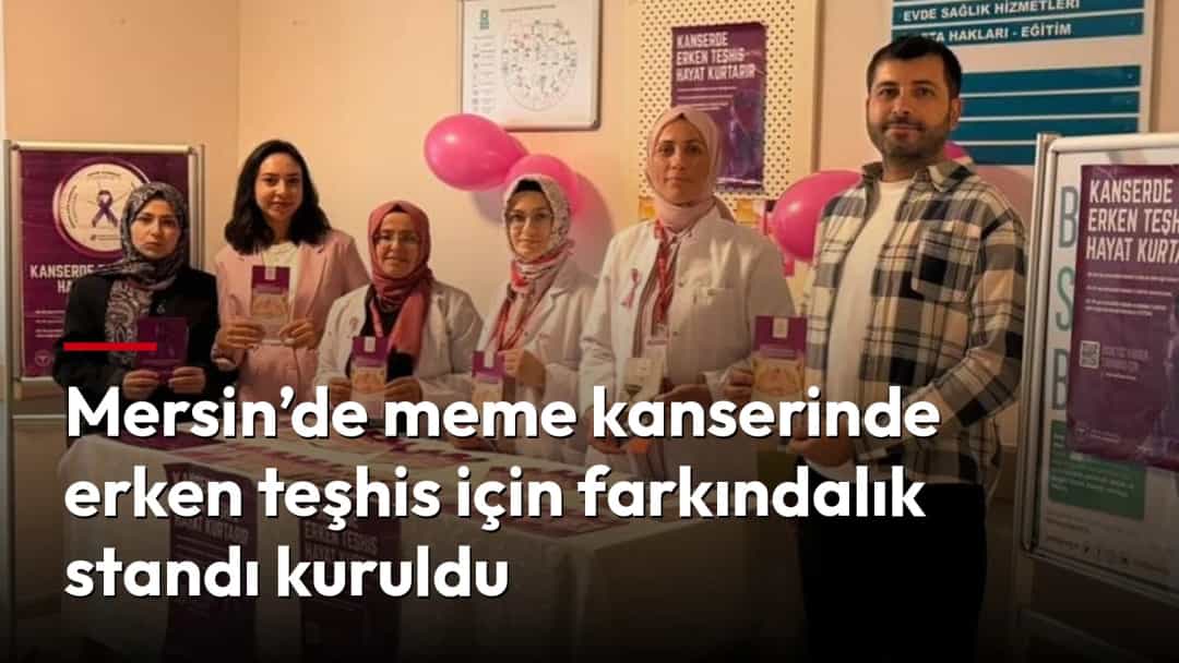 Meme kanserinde erken teşhis farkındalığı için kurulan stantta görevliler bilgilendirme broşürleriyle birlikte poz veriyor.