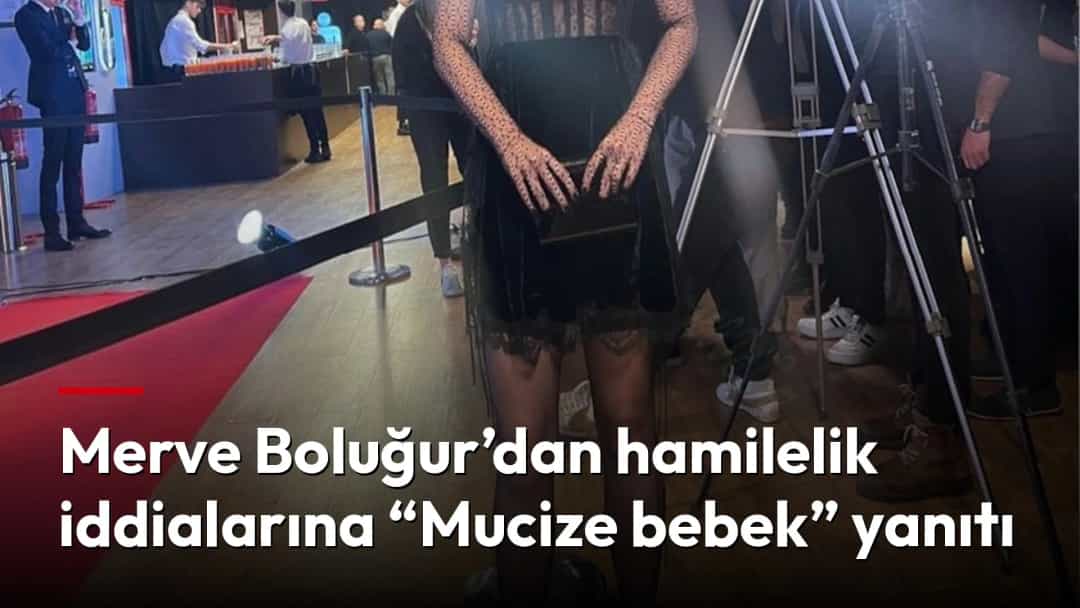 Merve Boluğur, siyah elbiseyle bir etkinlik alanında kameraların önünde poz veriyor.