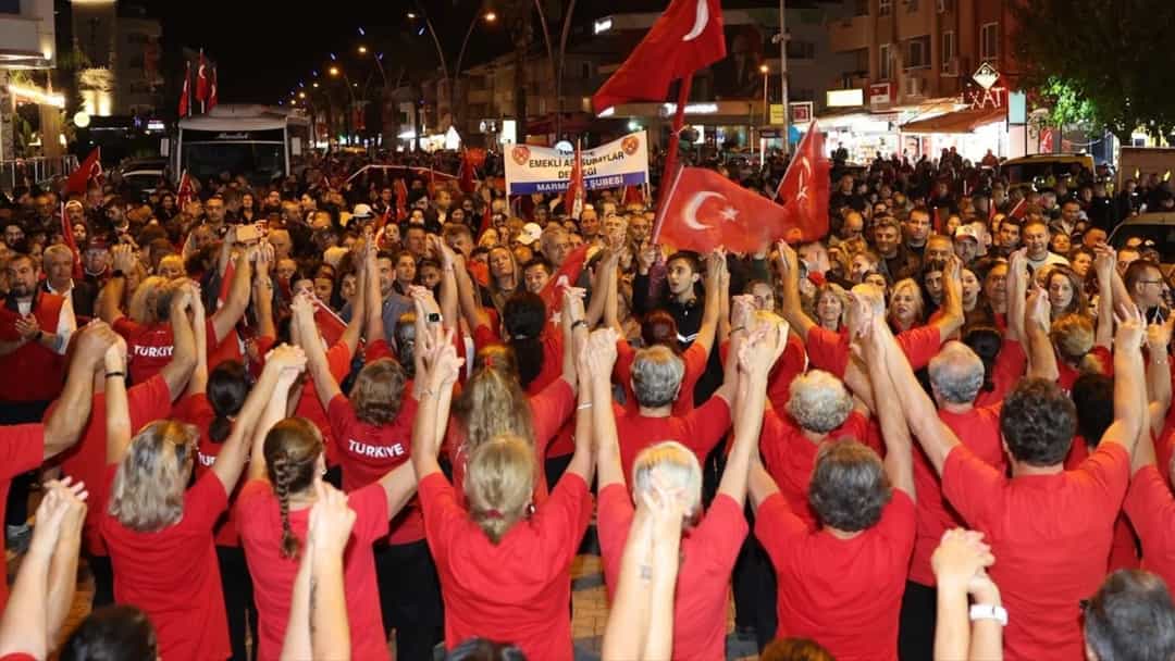 Muğla’da Cumhuriyet Bayramı fener alayında kalabalık, Türk bayrakları eşliğinde yürüyüş yapıyor.
